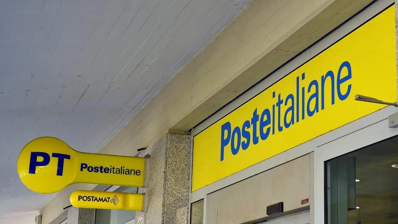 Insegne gialle di Poste Italiane, con logo PT e Postamat. Un invito a partecipare al concorso Poste Italiane.
