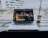 Un laptop aperto su un sito web che spiega cosa fa un content creator, con una bevanda accanto.
