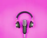 Microfono e cuffie su sfondo rosa, pronti per l'interpretariato di conferenza.