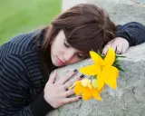 Ragazza con fiore giallo, triste, forse in attesa di un permesso per lutto suocero.