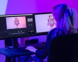 Ragazza studia effetti speciali per video, con monitor che mostra timeline e video. Corsi After Effects per creativi.