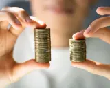 Due pile di monete, una più alta dell'altra, simboleggiano la differenza tra stipendi. Il **stipendio medio Lussemburgo** potrebbe essere rappresentato dalla pila più alta.