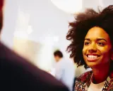Donna sorridente in primo piano, discute idee per capire che lavoro fare a 40 anni senza esperienza.