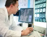 Tecnico radiologo analizza immagini mediche. Il suo stipendio è commisurato alla sua esperienza e responsabilità.