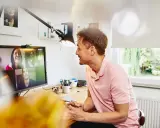 Uomo in videochiamata con colleghi, un esempio di lavoro da casa.