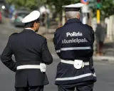 Due vigili urbani in divisa, uno con la scritta "Polizia Municipale" sulla schiena, in attesa di un equo stipendio.