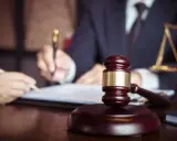 Martelletto da giudice e bilancia della giustizia, mentre si discute quanto guadagna un notaio.