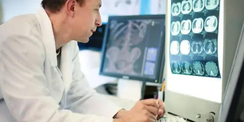 Tecnico radiologo analizza immagini mediche. Il suo stipendio è commisurato alla sua esperienza e responsabilità.