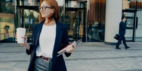 Donna con caffè e quaderni, pronta per il suo ruolo.