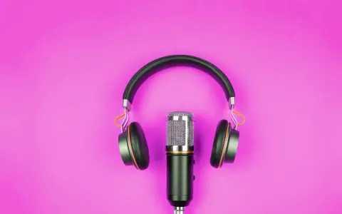 Microfono e cuffie su sfondo rosa, pronti per l'interpretariato di conferenza.
