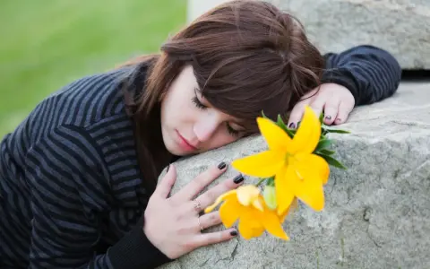 Ragazza con fiore giallo, triste, forse in attesa di un permesso per lutto suocero.