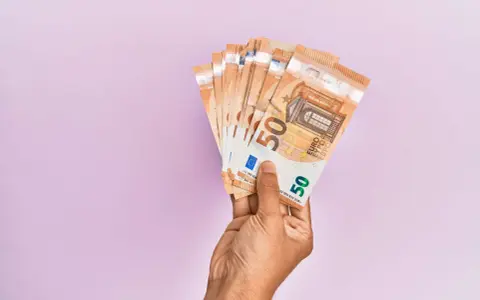 Mano che tiene banconote da 50 euro, pronte per quando si paga l'INPS.