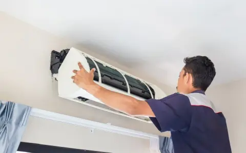 Un frigorista installa un condizionatore d'aria.