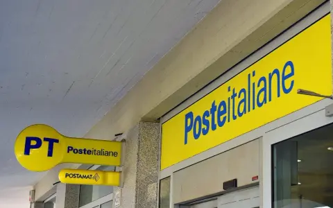 Insegne gialle di Poste Italiane, con logo PT e Postamat. Un invito a partecipare al concorso Poste Italiane.