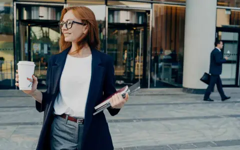 Donna con caffè e quaderni, pronta per il suo ruolo.
