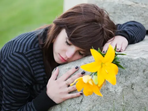 Ragazza con fiore giallo, triste, forse in attesa di un permesso per lutto suocero.
