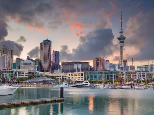 Skyline di Auckland al tramonto, con la Sky Tower e yacht ormeggiati. Un sogno per chi vuole lavorare in Nuova Zelanda.