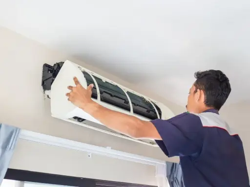 Un frigorista installa un condizionatore d'aria.