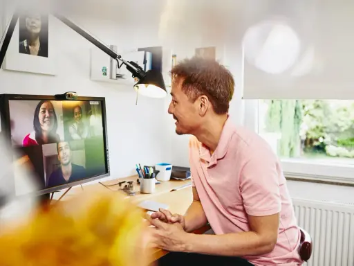Uomo in videochiamata con colleghi, un esempio di lavoro da casa.