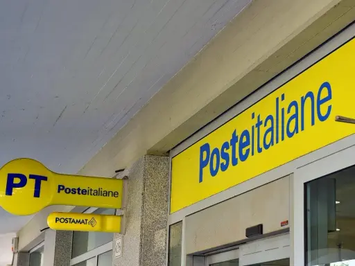 Insegne gialle di Poste Italiane, con logo PT e Postamat. Un invito a partecipare al concorso Poste Italiane.