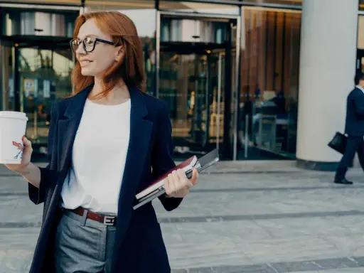 Donna con caffè e quaderni, pronta per il suo ruolo.