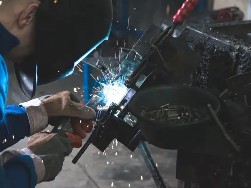 Manutentore meccanico al lavoro, con scintille luminose. Un mestiere che merita un buon stipendio per la sua abilità e precisione.