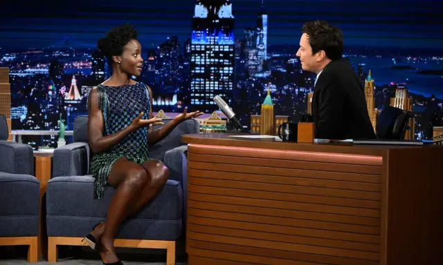 Lupita Nyong'o parla con Jimmy Fallon in uno studio TV. Un sogno che si avvera per chi vuole lavorare in TV senza esperienza.