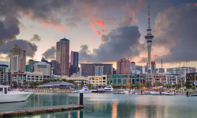 Skyline di Auckland al tramonto, con la Sky Tower e yacht ormeggiati. Un sogno per chi vuole lavorare in Nuova Zelanda.
