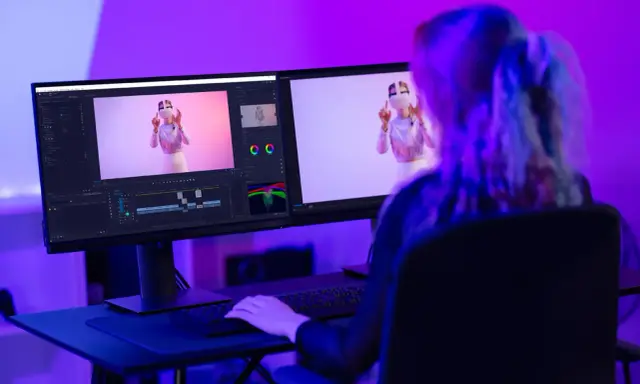Ragazza studia effetti speciali per video, con monitor che mostra timeline e video. Corsi After Effects per creativi.