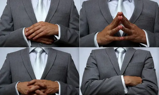 Uomo in abito grigio a righe, con cravatta chiara, che mostra diverse posizioni delle mani: incrociate, a diamante, e braccia conserte. Un modo per presentare con le mani.