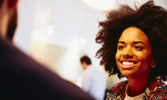 Donna sorridente in primo piano, discute idee per capire che lavoro fare a 40 anni senza esperienza.