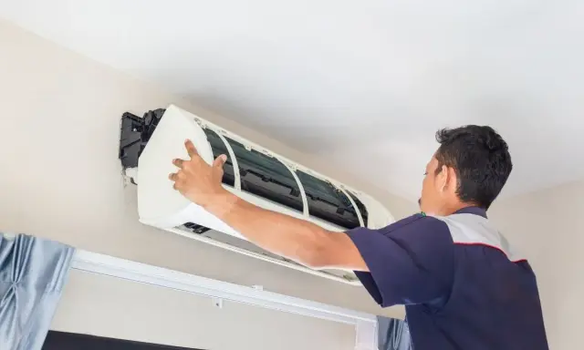 Un frigorista installa un condizionatore d'aria.