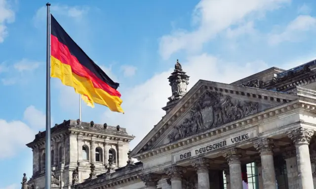 Bandiera tedesca sventola davanti al Reichstag. Impara il tedesco online gratis!