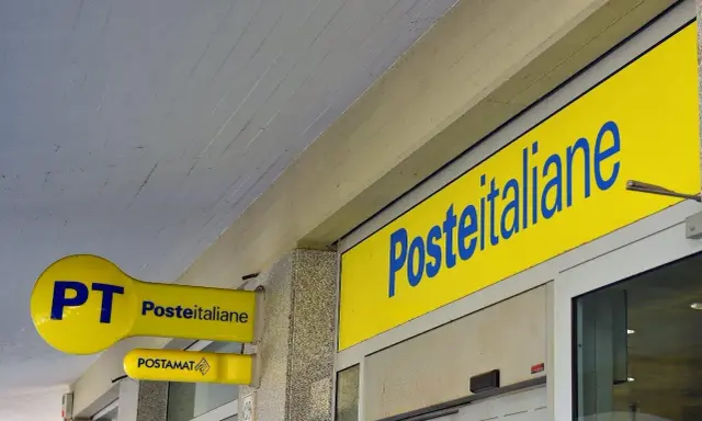 Insegne gialle di Poste Italiane, con logo PT e Postamat. Un invito a partecipare al concorso Poste Italiane.