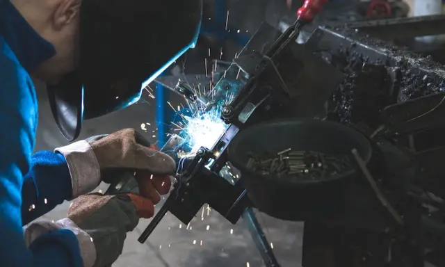 Manutentore meccanico al lavoro, con scintille luminose. Un mestiere che merita un buon stipendio per la sua abilità e precisione.