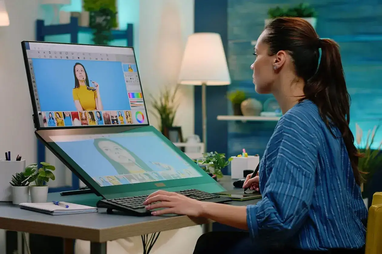 Ragazza impegnata nel corso di grafica digitale, ritocca foto su un monitor con tavoletta grafica.