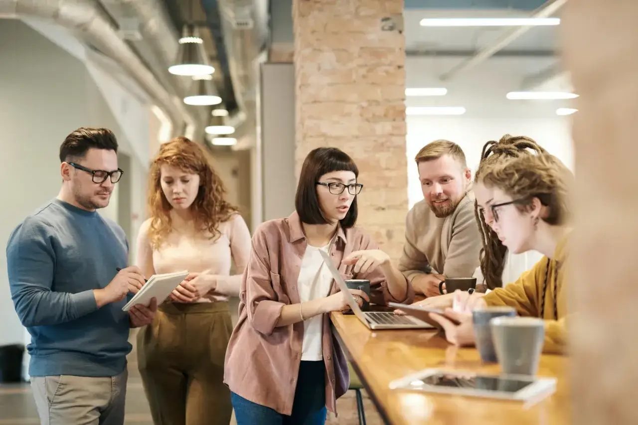 Un team discute idee, mostrando cosa fa un ingegnere gestionale: analizzare, pianificare e collaborare per il successo del progetto.