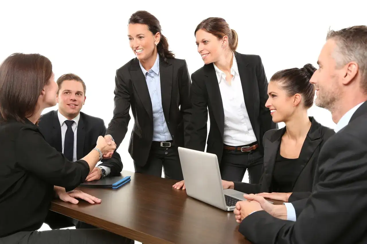 Team di professionisti in riunione, stretta di mano che simboleggia accordo e deontologia professionale.