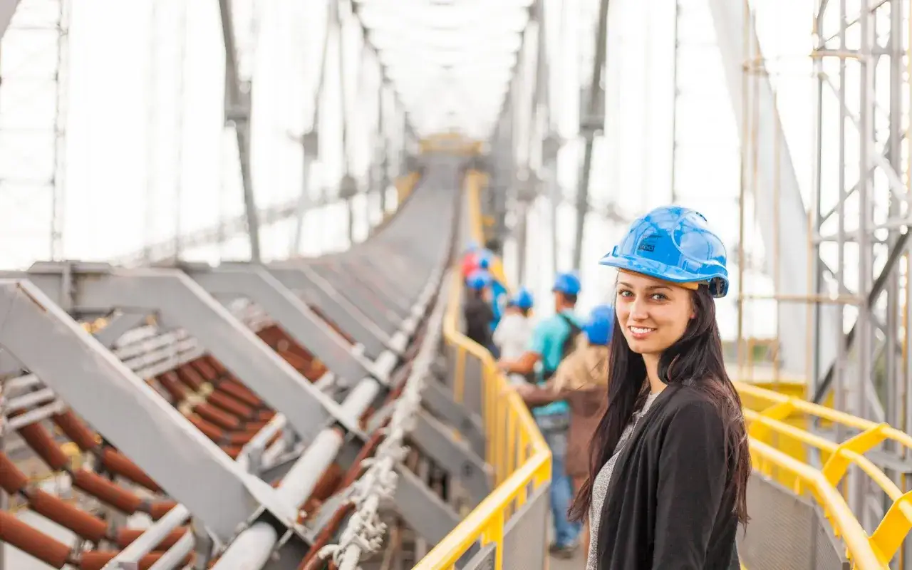 Donna con casco blu in un impianto industriale. Chiss&agrave; quando arriva il pagamento infortunio INAIL per i lavoratori.