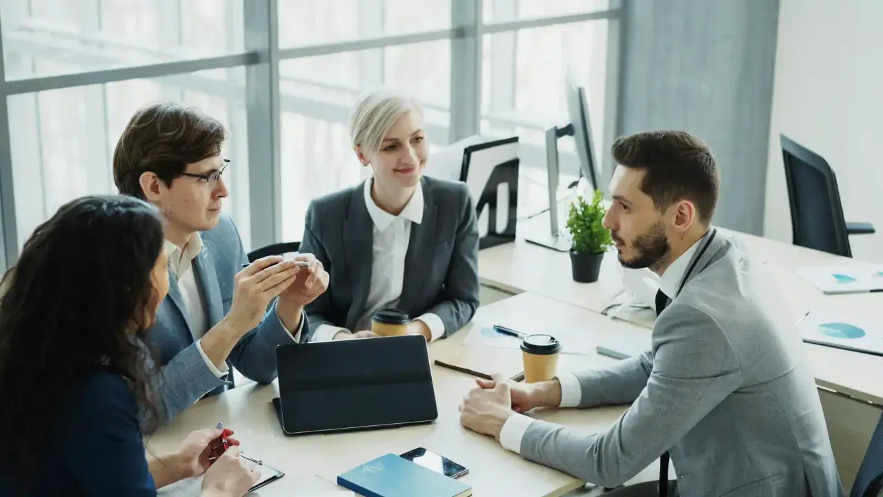 Un team di professionisti discute idee in un ufficio moderno, dimostrando un efficace lavoro di squadra.