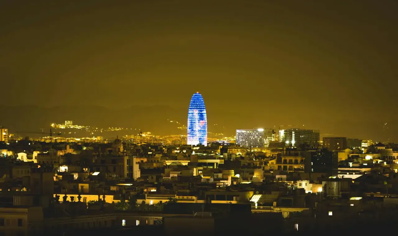 La Torre Gl&ograve;ries illumina la notte di Barcellona, un sogno di lavorare a Barcellona tra luci e architetture moderne.
